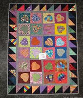 Front view of quilt showing patchwork heart squares and border