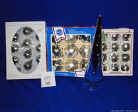 Three boxed sets of silver mercury glass ball ornaments and a 14-inch mercury glass tree displayed together