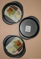 Three Wilton 8" round pans, two with labels visible