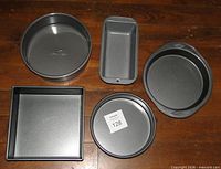 All five pans laid out: springform, loaf, Wilton round, 8" round, 9" square