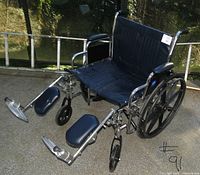 Full view of wheelchair showing seat, frame, wheels, leg rests