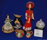 Group shot showing three dolls, two pottery pieces and oil lamp