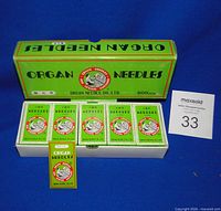 Outer box opened showing five inner packs of Organ needles, lot card visible