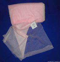 Folded soft pink dotted netting fabric on bolt with additional unfolded section displayed