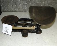 Scale assembled with scoop tray and flat plate visible, brass beam and weight shown