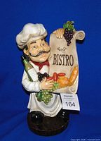 Front view of chef figurine with scroll and produce