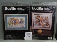 Front view of both sealed Bucilla cross-stitch kits