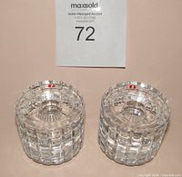 Two clear faceted cylindrical crystal candle holders side by side