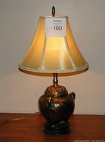 Full view of lamp illuminated showing shade and bronze base