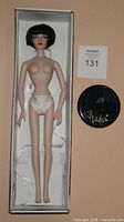 Doll in box with stand disk visible