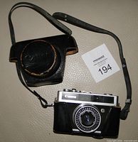 Front view of Canon Canonet Junior camera with case and strap