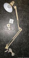 Full view of articulated lamp with clamp base and cord