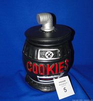 Front view of black pot belly stove cookie jar showing red COOKIES lettering and stove details