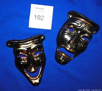 Front view of comedy and tragedy brass masks