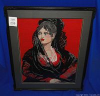 Front view of framed needlepoint portrait in black frame