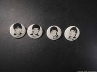 Front view of four ceramic Beatles portrait buttons