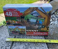 Front view of sealed 48-piece Building Site floor puzzle box with tape measure