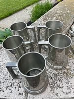 Group shot of all five pewter mugs on stone surface