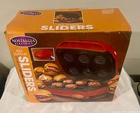 Front of boxed Nostalgia Electrics All League Sliders maker showing product image and capacity