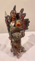 front view of figurine displaying spear, shield, feathered headdress