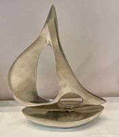 Front view of polished aluminum sailboat sculpture