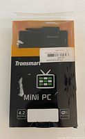 Front view of boxed Tronsmart mini PC showing branding and Android/Wi-Fi icons