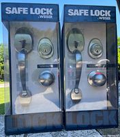 Front view of two boxed Weiser Safe Lock handle sets
