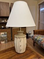 Full view of ceramic lamp with shade on table