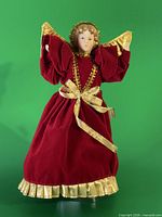 Front view of porcelain angel topper showing gown, wings, trim