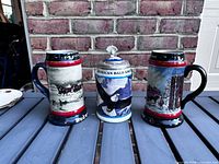 Front view of three Budweiser steins showing designs and condition