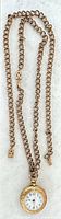 Pocket watch with attached double curb-link chain laid out full length