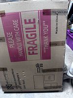 Sealed shipping box for Neutype mirror, showing branding and fragile handling instructions