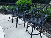 Three matching Frontgate aluminum swivel pub chairs poolside