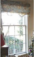 Valance hung on window showing floral pattern, scalloped edge, nailhead trim