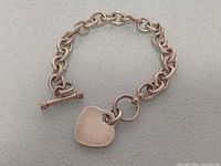 Full view of sterling silver bracelet showing heart tag charm and toggle clasp