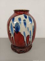 front view of drip glaze vase on wooden stand