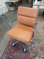 Front three-quarter view showing leather cushions, arms, base