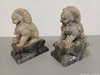 Front angled view of both soapstone guardian lion statues