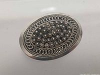 Front view of oval filigree silver pin