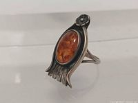 Side view showing amber cabochon and decorative silver setting