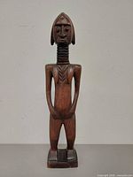Front view of carved Baule wood figure statue