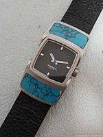 Front view showing dial, turquoise inlays, leather strap