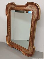 Front view of vintage gilded mirror showing frame details and reflective glass