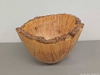 Overall view of burl wood bowl showing bark rim and grain