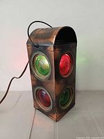 Front/side view showing copper-tone metal body and red/green lenses