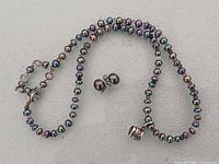 Full necklace with clasp, garnet charm and earrings visible