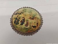 Front view showing painted scene and filigree border