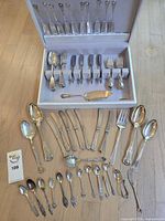 Overview of entire 40-piece sterling flatware set with storage case