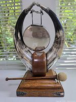 Full view of tabletop gong showing horns, gong disc, base and mallet