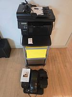 Overall lot view with printer on cart, elliptical and manuals in front